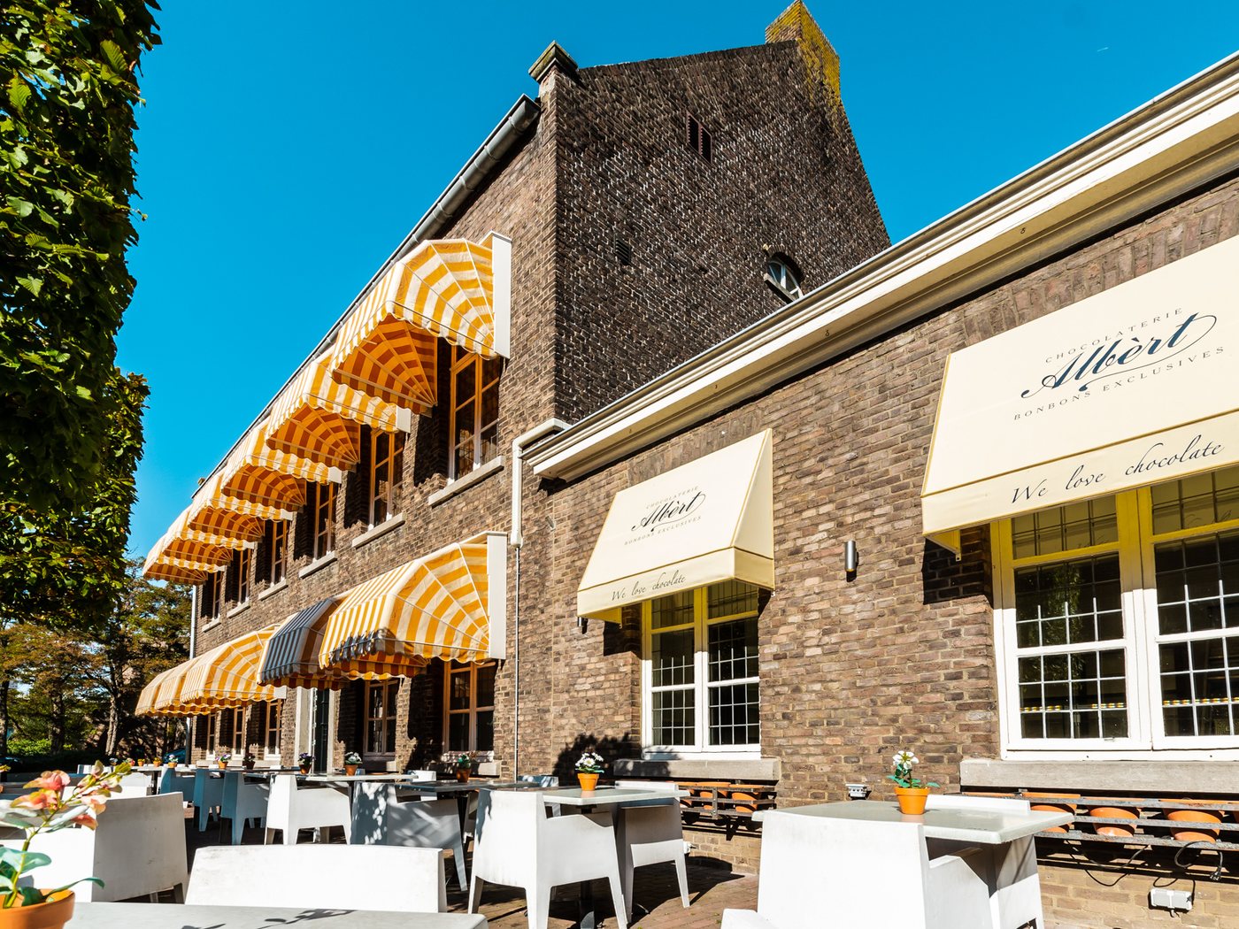 Het pand met het terras en de gestreepte zonneschermen