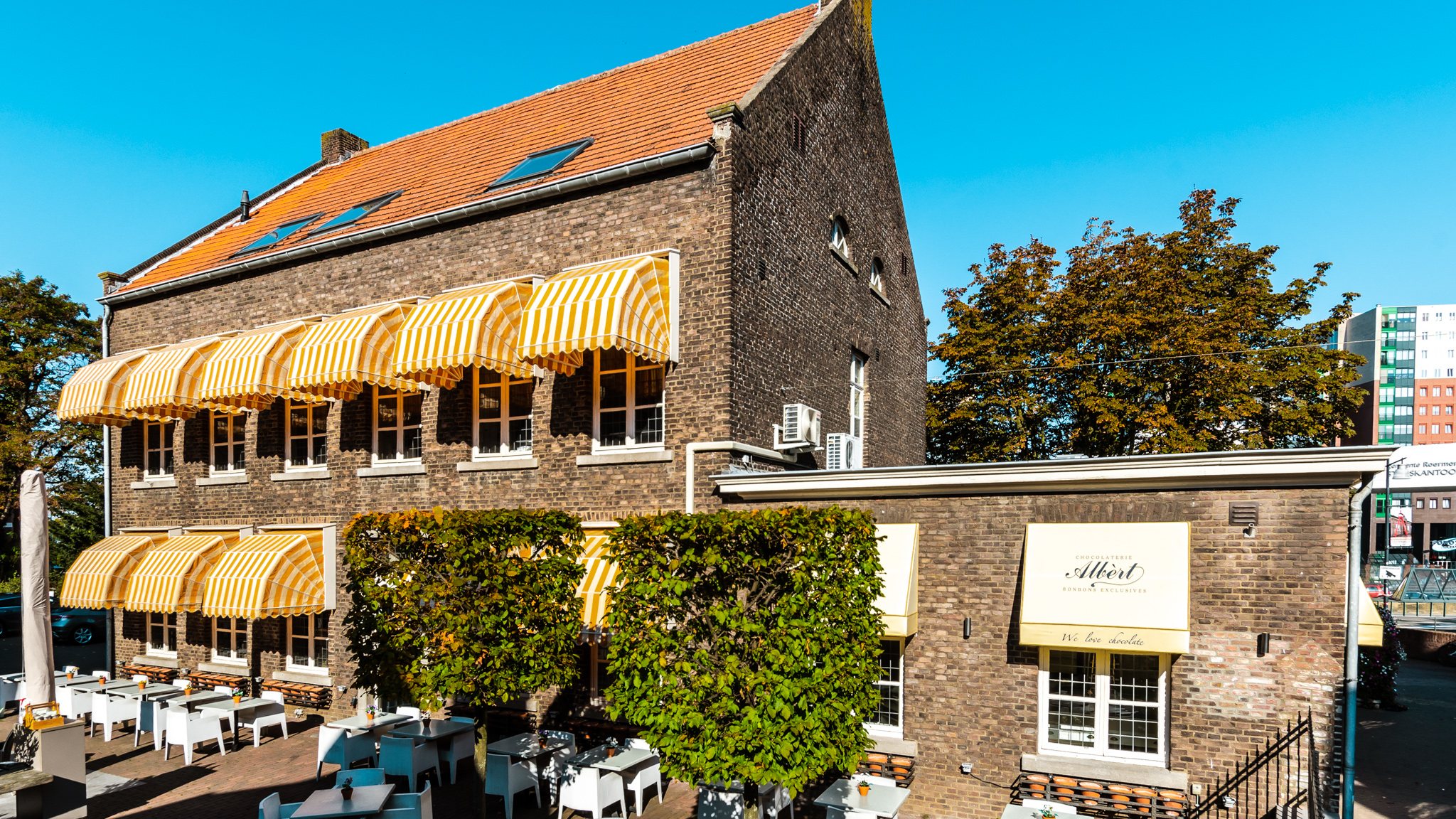 De Pastorie: het pand met de gele zonneschermen en het terras