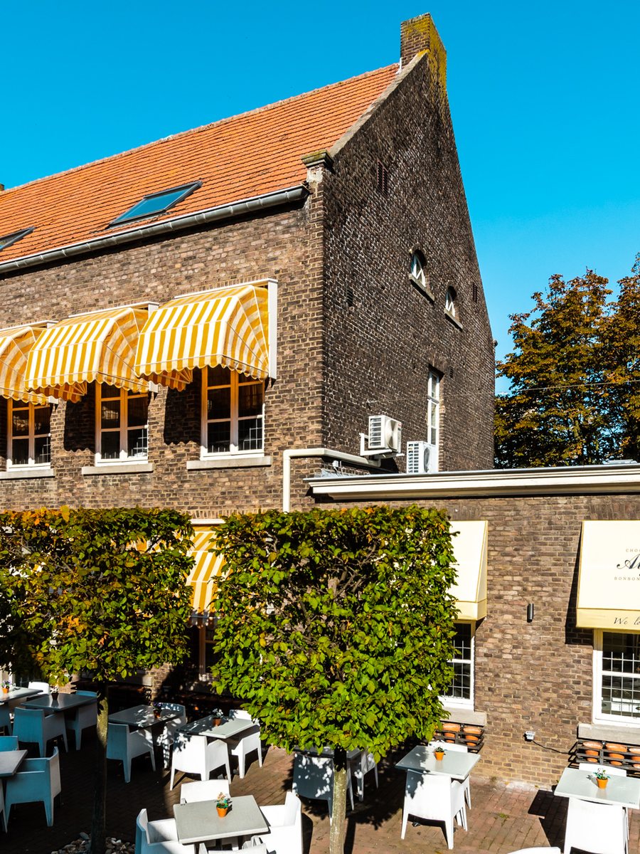 Het pand met het terras en de gestreepte zonneschermen